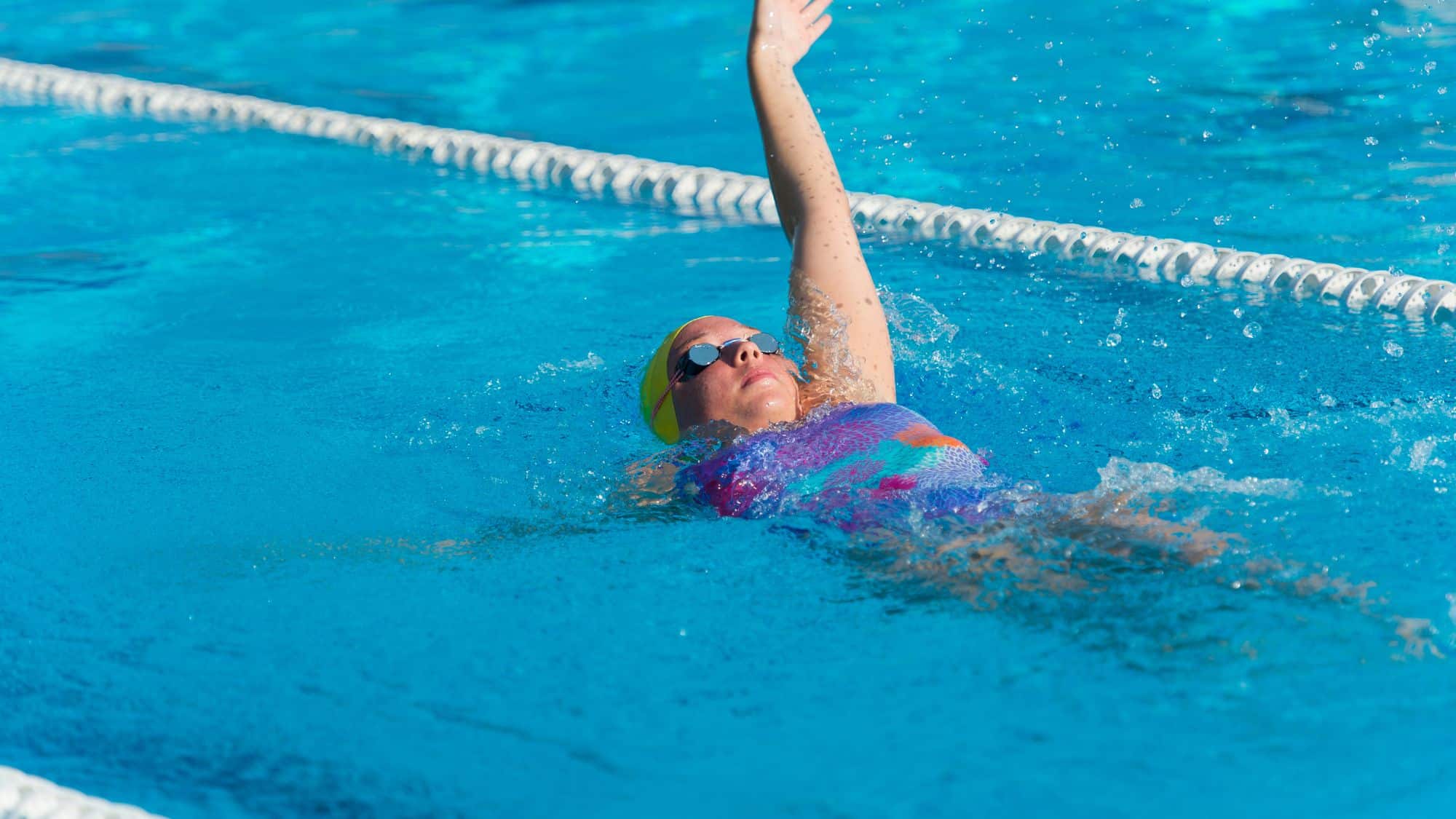 adult swimming in the lane swimming backstroke