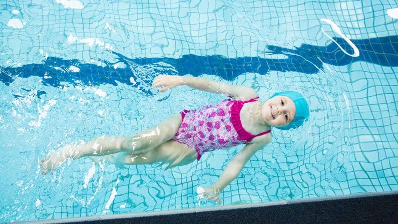 girl floating in swimming pool